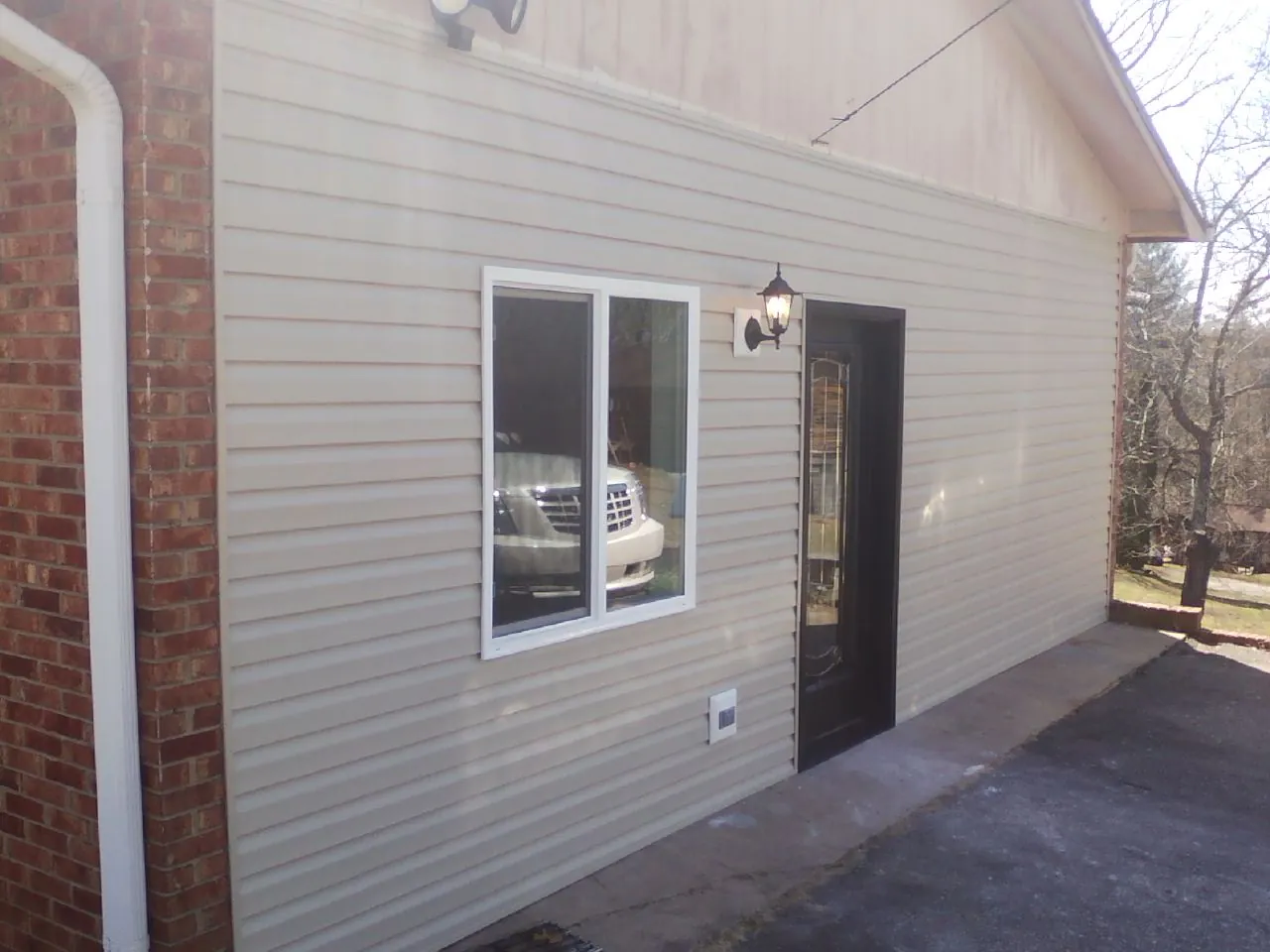 New vinyl siding and entry door on a room addition in Franklin